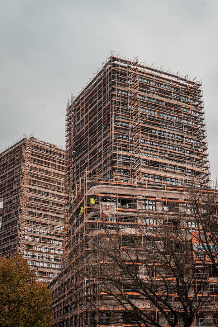 services-img High-rise buildings under construction with extensive scaffolding in an urban setting.