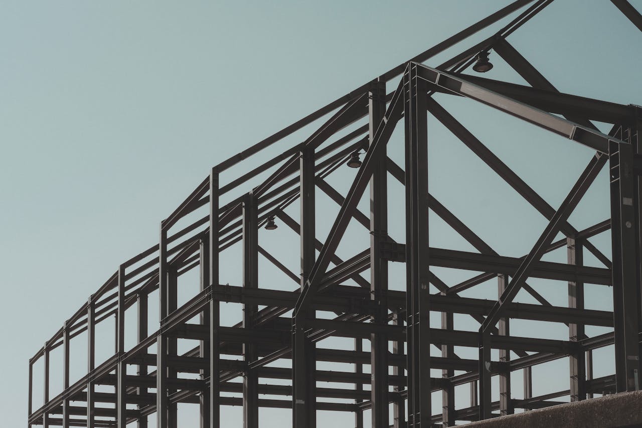 hero-img-02 Modern steel framework structure under clear sky, showcasing architectural design.