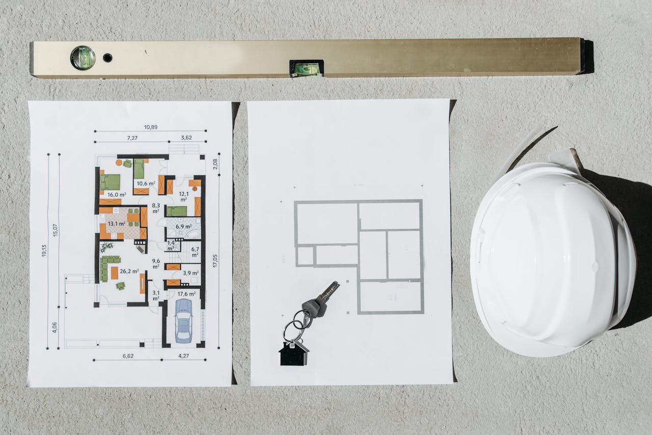 gallery-6 Blueprints, spirit level, and hard hat symbolize house planning.