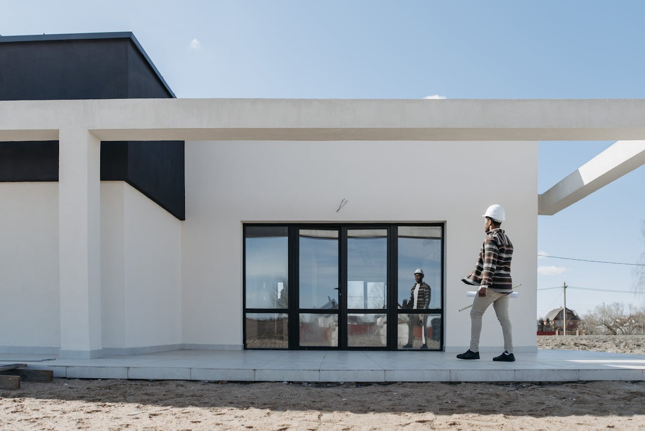 gallery-2 Architect with hard hat evaluating modern house exterior. Ideal for construction and architecture themes.
